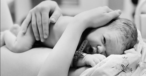 Newborn baby lying on mother's belly