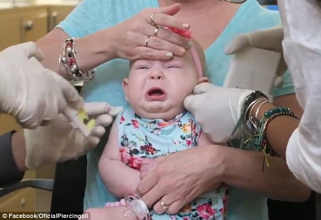 The video filmed in the US shows Crystal's four-month-old screaming out as she gets both of her ears pierced. She is heard wailing for about 30 seconds, but then appears to be fine 