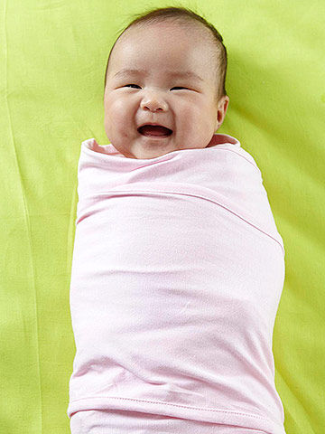 swaddled baby smiling