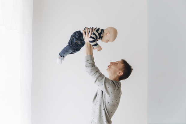 Caucasian father lifting baby son