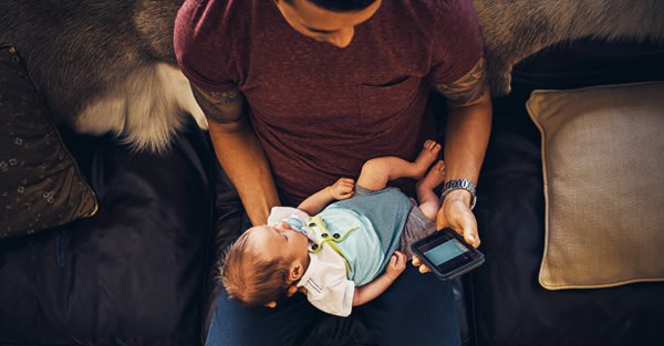 Dad on phone with newborn